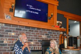 Submitted photo##At the celebration of VanDeVeere’s life, he and his wife, Nicole, take a moment to sit and reminisce. The quote on the screen above them refers to his many daring activities over the years — driving fast cars, boating, flying. Relatives and friends attended the party, which also celebrated Van’s 99th birthday.