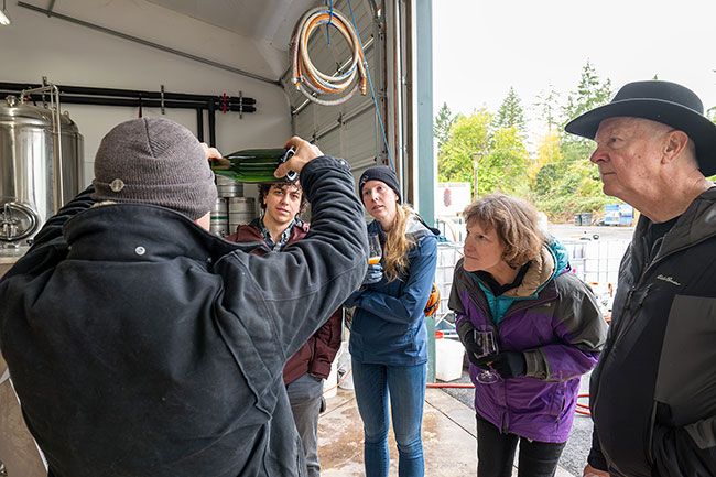 Rusty Rae/News-Register##RAW Cider Co. owner Levi Danielson gives a tour group an inside look at the fermentation process. The group, from Portland (from the left) are Brodie Torres, Kristen Colwell, Ellen Colwell (taking a closer look) and her spouse, Robert. Rusty Rae/News-Register##RAW Cider Co. owner Levi Danielson gives a tour group an inside look at the fermentation process. The group, from Portland (from the left) are Brodie Torres, Kristen Colwell, Ellen Colwell (taking a closer look) and her spouse, Robert.