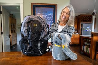 Rachel Thompson/News-Register##Karen Willard of McMinnville shows off her backpack from walking the Camino de Santiago in France and Spain, which shows off a patch declaring that she has cochlear implants and cannot hear people behind her; and a koala bear from the cochlear implant manufacturer in Australia, which she visited. She is thrilled with the implants, which allow her to hear and continue her many activities.