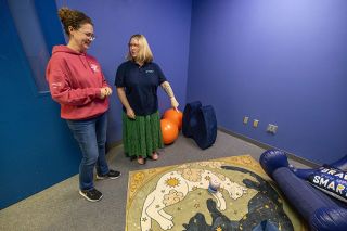 Rachel Thompson/News-Register##Rachel Godfrey, who started the Traveling Light Foundation in honor of her late son, Ronan, shows off the Sensory Room to Elizabeth Hinchcliff of Cruising McMinnville, left. The room is equipped with low lighting, comfortable seating and a canoe that hugs a child. All can be removed and replaced with other sensory equipment, as needed.