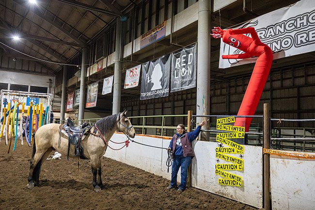 Rachel Thompson/News-Register##Shaena Johnson of Hillsboro sweetens the deal with horse cookies as Jeremiah of the Paisley Desert hesitates near a flailing inflatable “air dancer” during Spook Night. “He’s actually doing pretty good today,” Johnson said. “Some of these things are gonna be scary, regardless of where you see them. It’s just controlling the reaction. That’s why we do this.” The obstacle course is one of four hosted each year by the Yamhill County Sheriff’s Mounted Posse. Rachel Thompson/News-Register##Shaena Johnson of Hillsboro sweetens the deal with horse cookies as Jeremiah of the Paisley Desert hesitates near a flailing inflatable “air dancer” during Spook Night. “He’s actually doing pretty good today,” Johnson said. “Some of these things are gonna be scary, regardless of where you see them. It’s just controlling the reaction. That’s why we do this.” The obstacle course is one of four hosted each year by the Yamhill County Sheriff’s Mounted Posse.