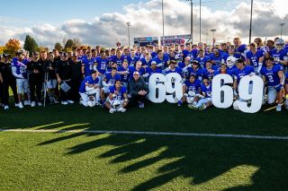 Rusty Rae/News-Register##The Wildcats pose for photographs at Maxwell Field, along with University President Mark Blegen (white hat), after their victory over Lewis and Clark and former Wildcat Brett Elliott extended The Streak to 69 seasons on Saturday, Nov. 1.