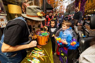 Rachel Thompson/News-Register##Arthur Knapp, dressed as a gumball machine, and fellow 6-year-old Henry McEachern, as Shadow the Hedgehog, pick out bubbles from Gail Craven outside Vintage on Third.