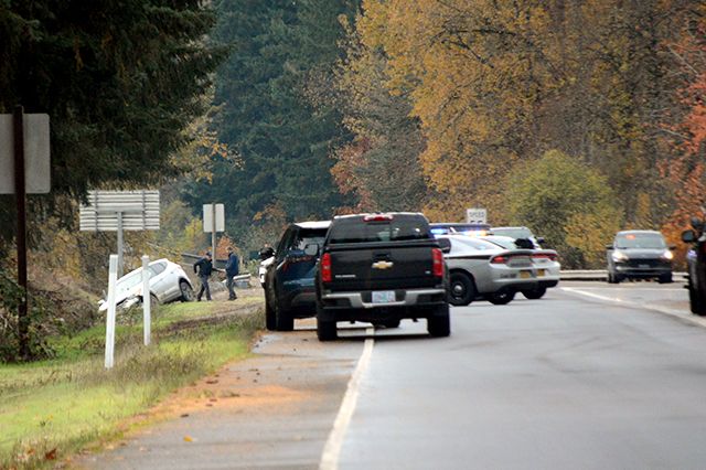Ossie Bladine/News-Register##Law enforcement officials investigate the scene on Highway 18 where two people were taken into custody following vehicle and foot pursuits.