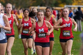 Nathan Ecker/News-Register##From left to right: Kathleen Robinson, Emily Pacheco Segovia, Josephine McPhillips, Angela Hernandez-Gallo and and Keira Christopherson (Mac’s top five girls finishers) run in tandem during the first lap of their 5000-meter conference championship race at Joe Dancer Park on Thursday, Oct. 30.