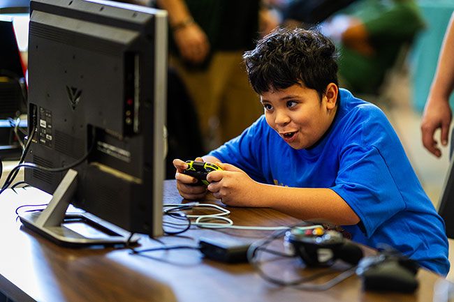 Rachel Thompson/News-Register##Eight-year-old Alex Albert of Salem leans into the action while competing in the Super Smash Bros. Ultimate tournament. The tournament was free to enter, with matches live-streamed on Twitch, a global platform for gaming events.