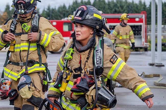Rachel Thompson/News-Register##Vallance and Perry reset their gear between drills. “There are not a lot of fires anymore,” said Fire Chief Reed Godfrey. “Back in the old days, firefighters got their training on the job. Nowadays, with sprinklers and fire alarm systems, it’s really decreased. Which is good — but inversely, that lessens their amount of actual hands-on training.” Because the department is “very well understaffed compared to our comparatives,” he said, drills like these are scheduled on firefighters’ days off. “Some of these guys came off from 48 hours away from their families,” Godfrey said. “Now they’re here for another four or five while we drill.”