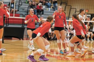Rachel Thompson/News-Register##Molly Tharp (No. 2), Shannon Shaver (foreground) and Gabi Leikam (right) gather for celebration of a kill by Payton Daum (No. 9) during the Grizzlies match against Forest Grove on Sept. 24. Daum and Tharp were key parts of the team’s offense.