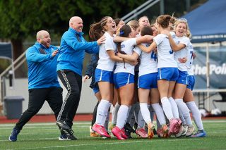 Rachel Thompson/News-Register##The Warriors girls soccer team and coaches run to embrace Grace Ulloa after netting the final score of the penalty shootout against No. 1 Valley Catholic, securing the teams championship victory.