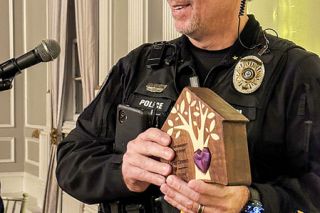 Submitted photo##Yamhill Police Chief Greg Graven accepts the Changing Hearts Impact Award from Juliette’s House for his dedication to protecting children and supporting families in Yamhill County. He was one of several winners of the nonprofit child abuse intervention center’s new Heart of the Community awards, given at an event Thursday. All the awards were handmade by woodworker Rolf Wuellner.