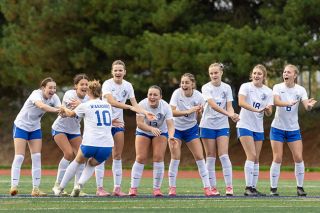 Rachel Thompson/News-Register##Adie Nisly (No. 10) receives high fives from her teammates lined up at midfield at Falcon Stadium in Hillsboro after scoring Amity’s third penalty kick in their championship shootout against Valley Catholic on Saturday, Nov. 15.