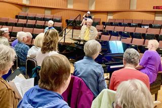 Submitted photo##John Buehler, a retired university music professor, conducts a rehearsal of the Yamhill Valley Community Chorus, which will make its debut Saturday, Nov. 22. Buehler and his wife, Susan, right, who plays piano for the chorus, moved to Oregon from Kansas and settled in Newberg in 2023. Chorus members are serious about music, Buehler said, but the rehearsals also include a lot of levity.