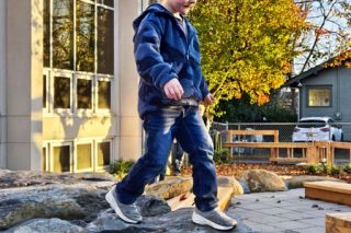 Submitted photo##Everett Morris, 5, balances as he walks along a line of boulders in the new playground at A Family Place, located in the McMinnville First Baptist Church. He attended the Thursday dedication of the playground, which is designed with natural features and plenty of places for young children to climb, slide and hide.