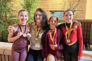 Submitted photo##Earth & Elevate instructor Jessie Tay, center, poses with members of the McMinnville aerial studio’s competitive team, including Natalie Kondor, left, Nisha Kumar and Holland Bertsch, right. The girls brought home medals from their first competition.