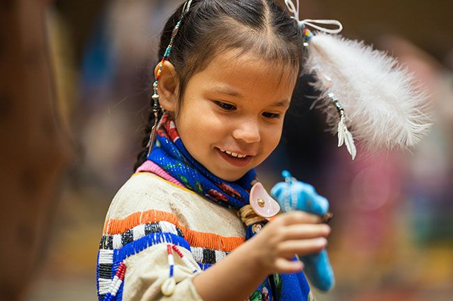 Rachel Thompson/News-Register##Beaming during the Grand Entry, 4-year-old Kaislee Rock of Salem holds up a toy horse while wearing a handmade buckskin dress passed down from her grandmother, Margaret Horn-Sampson, who wore it herself at the same age. Rachel Thompson/News-Register##Beaming during the Grand Entry, 4-year-old Kaislee Rock of Salem holds up a toy horse while wearing a handmade buckskin dress passed down from her grandmother, Margaret Horn-Sampson, who wore it herself at the same age.