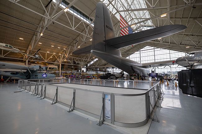 Rachel Thompson/News-Register##The Glide and Gather skating rink, which is made up of panels of synthetic ice, is set up under the tail of the Spruce Goose in the Evergreen Aviation Museum. Visitors can skate every weekend through the holiday season. They also can choose to tour the museum’s Goose Lights attraction, in which planes and helicopters are outlined with colored bulbs.