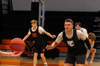 Nathan Ecker/News-Register##Yamhill Carlton senior Deegan Tuning glues his eyes to a basketball held by Tigers Head Coach Marty McLaughlin during a lateral drill at a practice session on Monday, Nov. 24, inside the Tiger Dome. Tuning is hoping to lead a team that can mature as the season progresses.