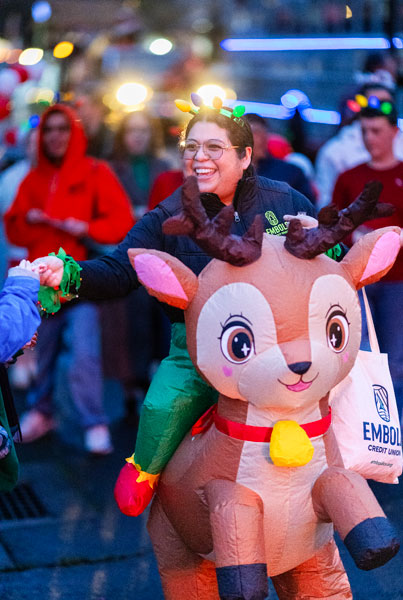Rachel Thompson/News-Register##Imelda Madrigal, an employee development trainer with Embold Credit Union, hands out candy from &ldquo;atop&rdquo; an inflatable reindeer.