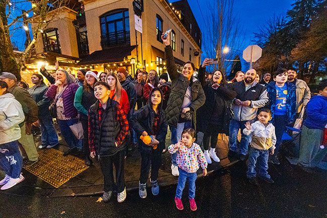 Rachel Thompson/News-Register##Crowds line the corner of Third and Galloway streets during the Santa Parade, watching floats and performers pass by.