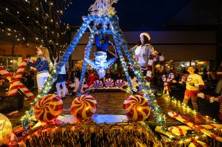 Rachel Thompson/News-Register##Earth & Elevate performers showcase an aerial routine on their peppermint-themed float during Friday’s Santa Parade.