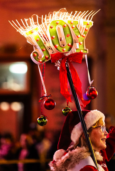 Rachel Thompson/News-Register##Lights and ornaments brighten a decorated rake carried by &ldquo;Rakette&rdquo; Christine Pritts of the McMinnville Garden Club during Friday&rsquo;s Santa Parade. The club walked with a banner celebrating its upcoming 100th anniversary in 2026.