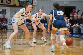 Rachel Thompson/News-Register file photo##Seniors Alyssa McMullen, left, and Adie Nisly, center, get set on defense against Banks guard Nylah Vanthom, right, during the 24-25 3A State Championship game at Marshfield High School on March 8, 2025. Amity enters the season relaxed and does not feel pressured to defend its title.