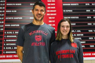 Nathan Ecker/News-Register##Murilo Martins, left, and Dakota Armour, right, pose for a photograph in front of the McMinnville high school and club swimming record board inside of the McMinnville Aquatic Center. The duo are working as dual head coaches, focusing their time on building the best environment for their athletes.