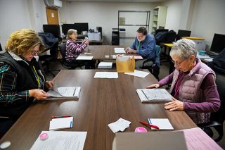 Rusty Rae/News-Register##Working in teams of two, (front) Jan Bunn, left, and Candace Duer and (back) Linda Dollinger, left, and Dan Willis verify votes during a recount of the McMinnville rec bond election on Tuesday in the basement of the Yamhill County Clerk’s Office. A staff member joined them in the room while the clerk and other observers watched from another room via a live camera feed.