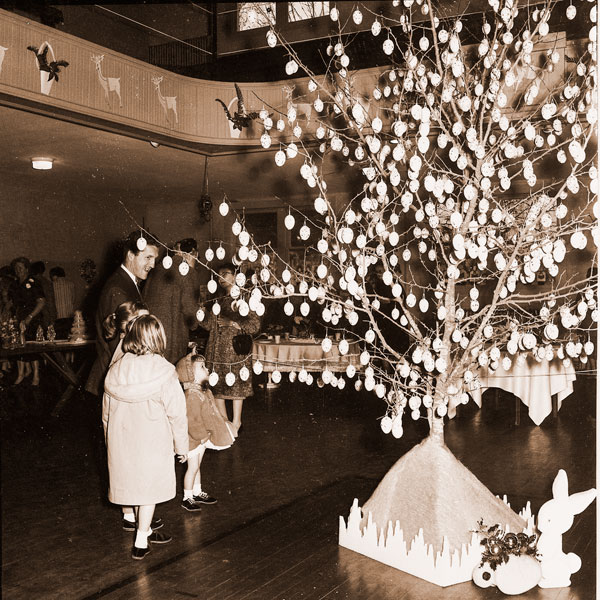 ##(Dec. 8, 1965) Kunnie Hendershott decked this tree with more than 800 eggs trimmed with glitter to create a holiday decoration which reminded viewers of Easter. The tree, viewed by Jim Hartzell and children, was one of many trimmed by members of the McMinnville Women&rsquo;s Garden Club for their Holiday Inspirations show Sunday