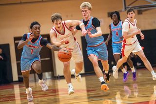 Rusty Rae/News-Register file photo##Grizzlies&rsquo; senior guard Dylan Ferrua (center) races for a loose ball against McDaniel&rsquo;s Trae Crawford (left) and Emmet Letson (right) during Mac&rsquo;s 71-67 overtime win over McDaniel on Friday, Dec. 12 inside of the McMinnville High School gymnasium. Ferrua netted 31 points in the game and kept his shooting stroke alive versus the Scots on Dec. 16.