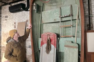 Kirby Neumann-Rea/News-Register
Wolves & People&rsquo;s&nbsp;Christian DeBenedetti stands with a vintage power boat that&rsquo;s been in the former Newberg auto shop for years. The boat will remain and become part of the new venue&rsquo;s decor. It has the label YC2, meaning it is just the second marine license issued in the county.
