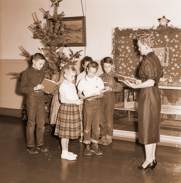 ##(Dec. 16, 1960) Cook school children (front row) Becky Jensen and Danny Graves (back row) Craig Beard, Lora Loban, Vicky Day and Brent Geary, ready a Christmas song under guidance of teacher Mrs. Jean Hoem. Mrs. Hoem wrote several of the songs to be performed by the Monday night at the school during &ldquo;An Album for Christmas&rdquo; program.