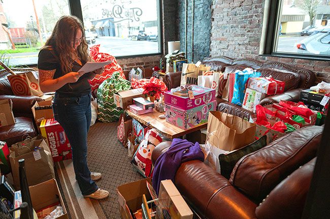 Rusty Rae/News-Register##Hannah Spenner, during her first day on the job as CASA recruitment and training coordinator, makes a list and checks it twice to ensure gifts are wrapped and addressed to the right local youth.