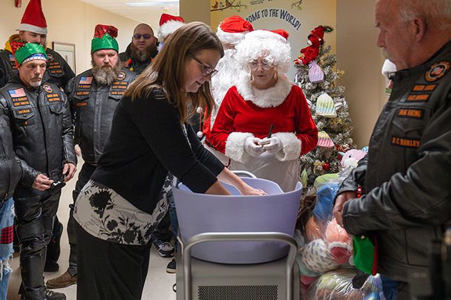 Rusty Rae/News-Register##Jennifer Von Derahe, director of the Women&rsquo;s Clinic at Willamette Valley Medical Center, demonstrates how the Caring Cradle can be used to give grieving parents more time with their babies. BC Harleys raised $2,950 so the hospital could have the special piece of equipment.