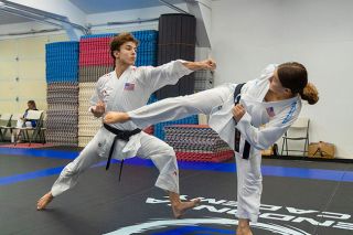 Nathan Ecker/News-Register##Logan Mendonca (left) and Mackenzie Mendonca (right) spar on the mat during a training session at Mendonca Academy. The duo are top-ranked international karate athletes and train vigorously year round, as well as compete in other sports as students at McMinnville High School.