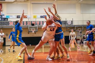 Rusty Rae/News-Register##McMinnville&rsquo;s Ruby Riddle absorbs the contact to make room for a shot at the basket. Riddle scored 11 of her 18 points in the fourth quarter against Barlow.