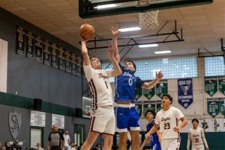 Nathan Ecker/News-Register##Dayton senior Tanner Gentry (left) rises toward the rim as Amity senior Diego Dubay Lomeli (right) reaches out for a block during the Warriors 60-51 victory over the Pirates in the black bracket championship at the Crusader Classic in Salem on Saturday, Jan. 3.