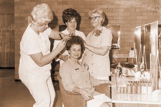 ##(Jan. 2, 1971) The McMinnville Beauty School opened Dec. 22 with 24 students. Pictured at the school are: (I-r) Tammy Foster, student doing a hairstyling, Judy Maahs, student, observing, Mrs. Swigart, instructor, also observing. Seated is Miss Ruth, instructor.