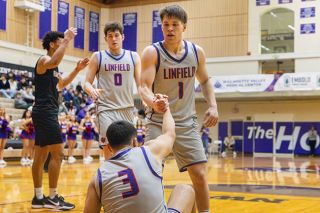 Nathan Ecker/News-Register##Chase Bennett (No. 1) provides a helping hand to Dayton Magana after Magana went to the floor on a hard foul in Linfield&rsquo;s victory over Willamette on Tuesday, Jan. 13 at Ted Wilson Gymnasium. The team&rsquo;s connectivity helped them rise to the occasion against a higher ranked Northwest Conference opponent.