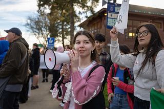 Rachel Thompson/News-Register##Student walkout organizer McMinnville High School senior Perla Mendoza Morfin addresses participants through a megaphone during the Free America Walkout on Tuesday outside the McMinnville Public Library. Mendoza Morfin, who previously spoke at a city council meeting on immigration enforcement, said she posted about the walkout on social media to fellow students and was unsure how many would attend. &ldquo;But we got a good amount,&rdquo; she said. &ldquo;I&rsquo;m glad to see everyone come together.&rdquo;
