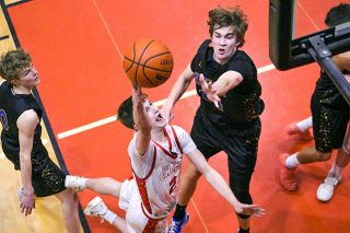 Rusty Rae/News-Register##Senior guard Owen Richardson rises to the hoop with Newberg&rsquo;s Jack Thompson in tow during the Grizzlies&rsquo; loss to the Tigers on Tuesday, Jan. 20, inside the McMinnville High School gymnasium. Thompson torched Mac for 18 points, including 16 in quarter No. 2.