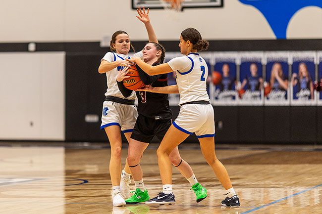Rachel Thompson/News-Register file photo##Amity&rsquo;s Alyssa McMullen, left, and Lyliana Rideout, right, trap Dayton&rsquo;s Bella Lopez during the rivalry contest on Jan. 16 in Amity.