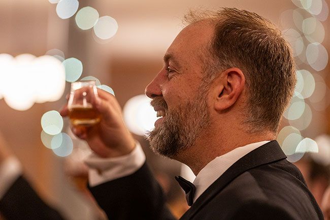 Rachel Thompson/News-Register##Chris McLaran raises his glass during one of the traditional whisky toasts made throughout the evening.