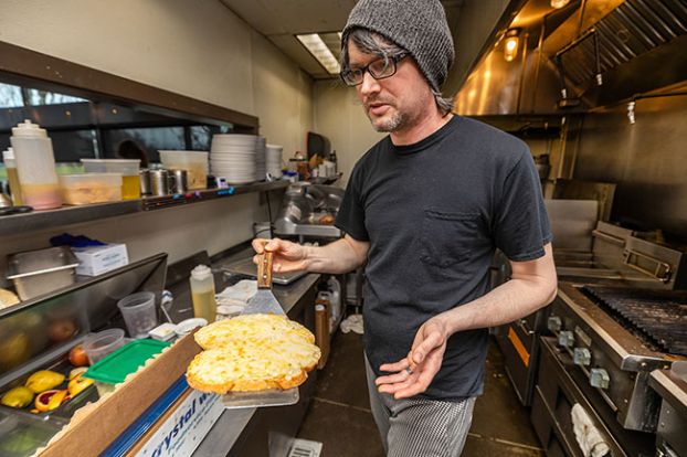 Rachel Thompson/News-Register##TJ Humphreys, chef at The Diner in McMinnville, removes toasted sourdough slices covered with melted cheese from the grill as he makes a Melt Down special. He also will add garlic aioli, red onion jam and slices of Eola Hills prime rib for the sandwich, which is part of the food bank fundraiser that will run throughout February. The Diner, which has participated in the Melt Down since it started in 2017, is one of 53 businesses taking part this year.