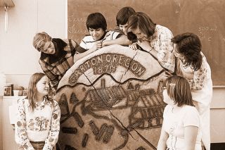 ##(Jan. 28, 1976) Eighth grader Tony Velarde at Carlton Grade School designed the above woodcarving which depicts historic scenes from Carlton. He received help from local craftsman Mel Wasson and other students. Pictured are from left, Sheila Long, Don Stanhope, Tony, Jeff Collins, Vicky Roberts, Sarah Warner and Nancy Von Euw. Tony spent two weeks working on the slab from a 492 year-old-log. Carving will be on permanent display at the school and is part of Carlton Bicentennial effort centered around a history of Carlton, prepared by students and adult advisers, scheduled for publication in book form next spring. Bicentennial Club will meet tomorrow to discuss cover and title ideas. Project workers plan soon to issue 1,000 subscription fliers.