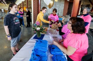 Rachel Thompson/News-Register##Freshmen Natalie St. Lawrence, left, and Katy Kaelin, center, talk with Soroptimist members, including Dorene Gleason, seated at the registration table, as they arrive for Dream It, Be It, an annual event the organization sponsors to encourage girls to set goals and think about their education and careers.