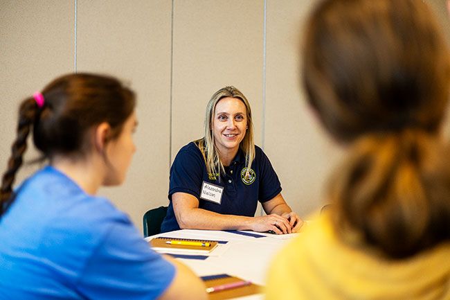 Rachel Thompson/News-Register##Alexandra Nielsen, a former law enforcement officer who now is a private investigator and business owner, tells students about her professional experiences during the career event. Nielsen was among several women who shared stories and advice with participants.