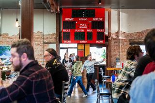 Rusty Rae/News-Register##Customers at Two Dogs Taphouse eat, drink and socialize under the scoreboard used in The Furnace, the gym at McMinnville High School, for almost 40 years. The scoreboard has three digits for recording basketball points &mdash; legendary Grizzly player Charlie Sitton led scoring that topped 100 points, making an older two-digit scoreboard obsolete.