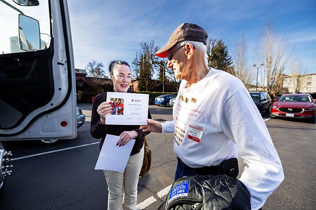 Rachel Thompson/News-Register##Colleen Murphy, account manager for the American Red Cross, presents a certificate to Walter Wierenga of McMinnville on the occasion of donating his 160th pint of blood &mdash; 20 gallons in all. Walter also received another one-gallon pin to add to the 19 others lined up on the front of his shirt.