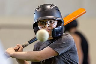 Rachel Thompson/News-Register##Calvin McLennan of Newberg keeps his eyes on the ball while swinging a flat bat trainer at a NW Forge hitting camp. McLennan attends the camp with his brothers and makes the short trip west along with several families.
